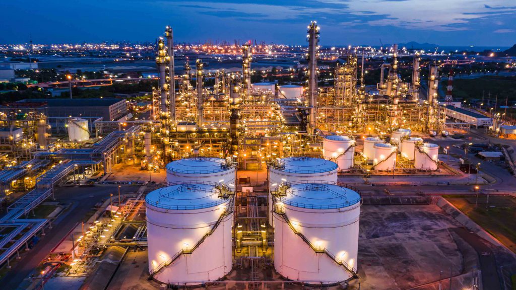 industrial oil and gas LPG refinery industry and commercial storage facilities import and export international by sea transport vessels aerial view at night in Thailand