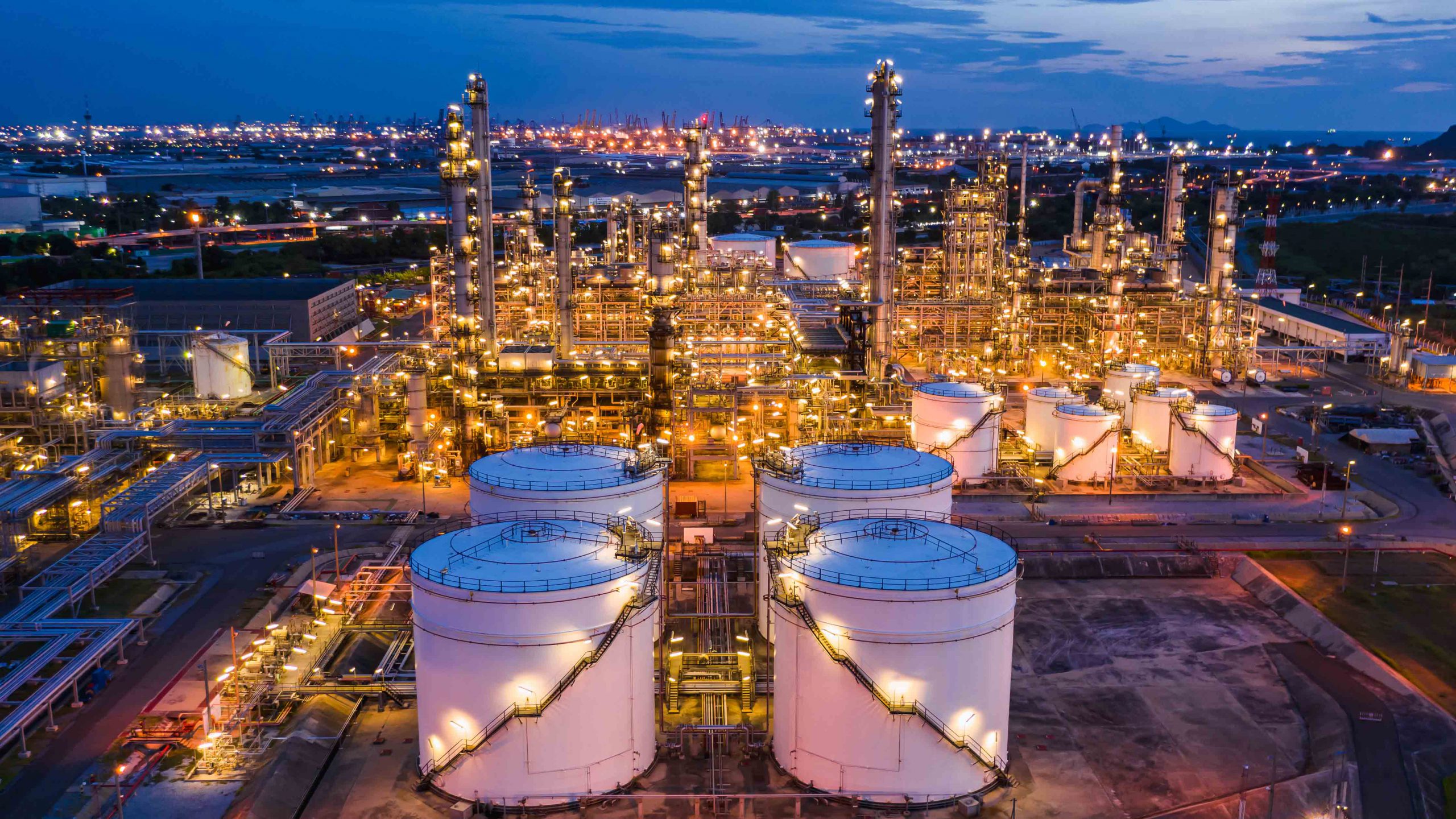 industrial oil and gas LPG refinery industry and commercial storage facilities import and export international by sea transport vessels aerial view at night in Thailand
